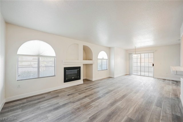 unfurnished living room featuring a textured ceiling and wood-type flooring