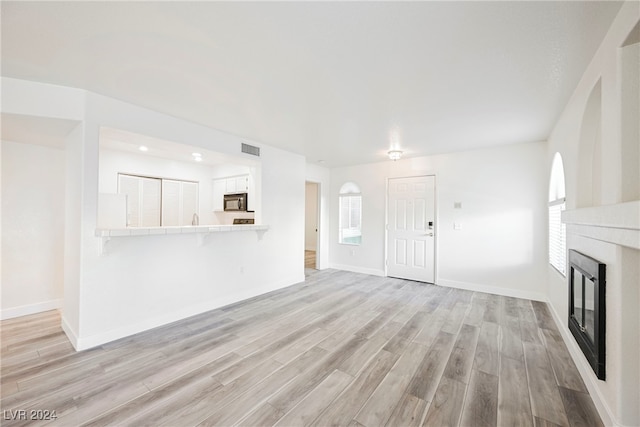 unfurnished living room with light hardwood / wood-style flooring