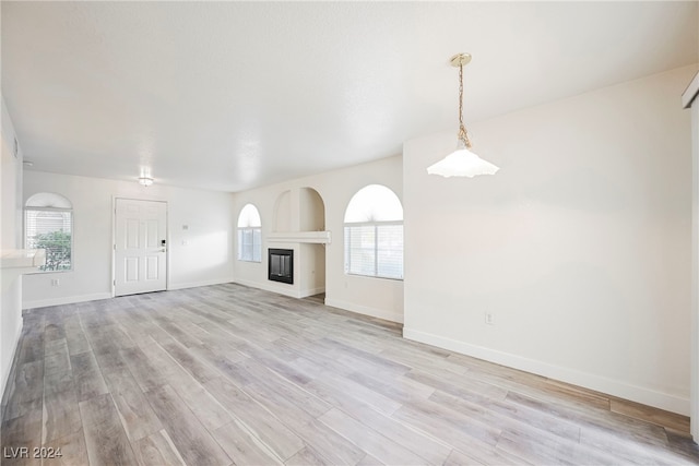 unfurnished living room with a healthy amount of sunlight and light wood-type flooring