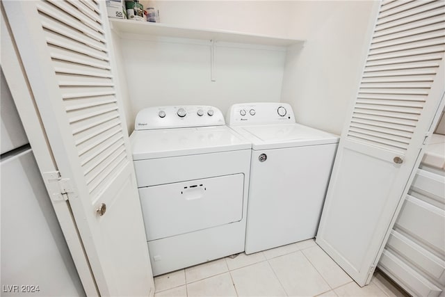 laundry area with washing machine and dryer and light tile patterned floors