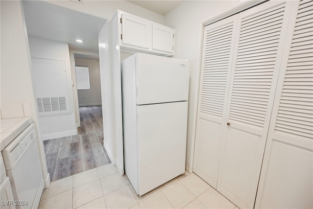 kitchen with tile countertops, light hardwood / wood-style flooring, white cabinetry, and white appliances