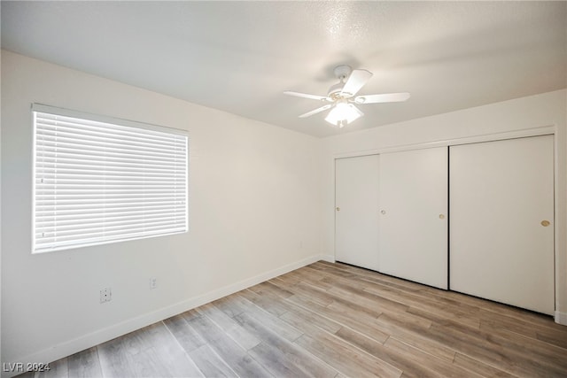 unfurnished bedroom featuring a closet, light wood-type flooring, and ceiling fan