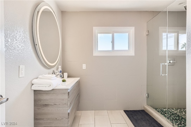 bathroom featuring tile patterned flooring, plenty of natural light, walk in shower, and vanity