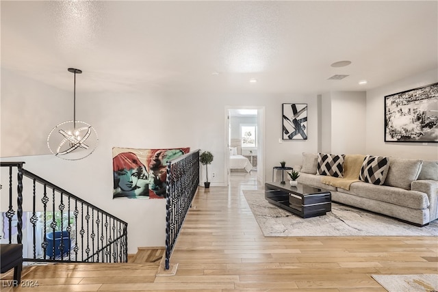 living room with hardwood / wood-style floors and an inviting chandelier