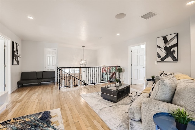 living room featuring a chandelier and light wood-type flooring