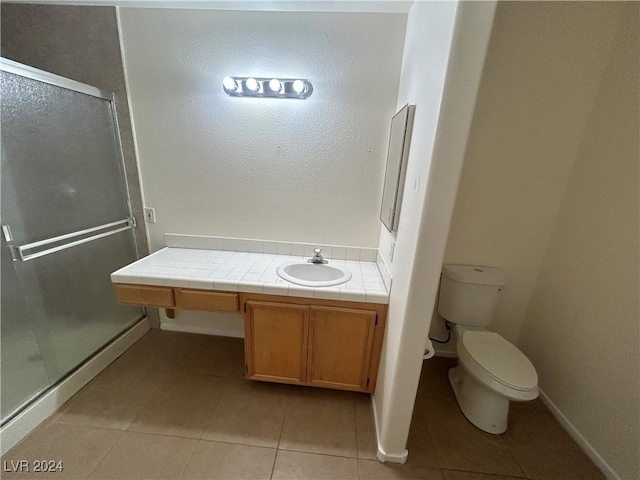 bathroom featuring vanity, tile patterned flooring, an enclosed shower, and toilet