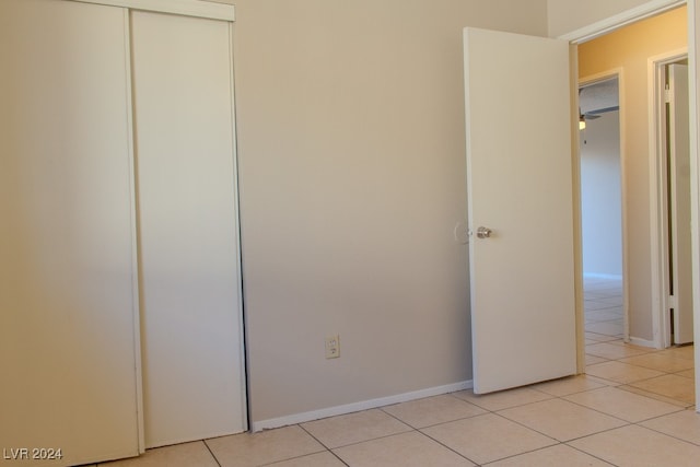 unfurnished bedroom with light tile patterned floors and a closet