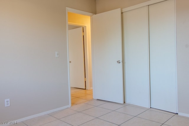 unfurnished bedroom featuring light tile patterned floors and a closet