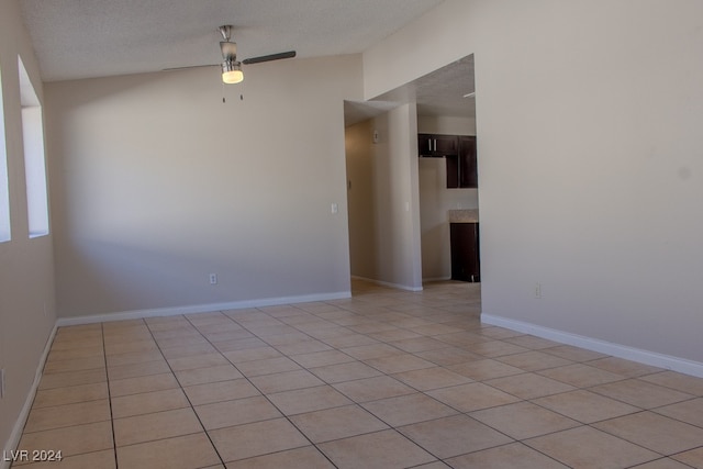 tiled empty room with a textured ceiling and ceiling fan