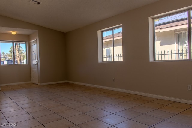 spare room featuring plenty of natural light and light tile patterned floors