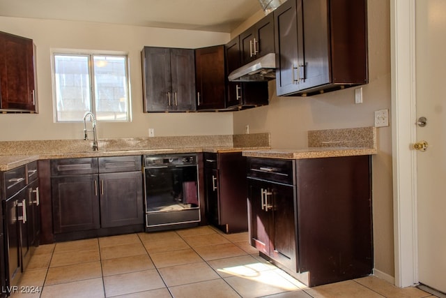 kitchen featuring dark brown cabinetry, sink, black dishwasher, light stone counters, and light tile patterned floors