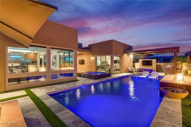 pool at dusk featuring a patio area, a jacuzzi, and a fire pit