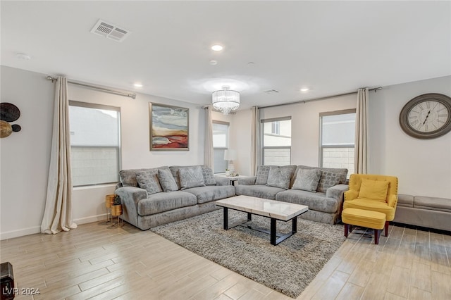 living room with a notable chandelier and light hardwood / wood-style floors