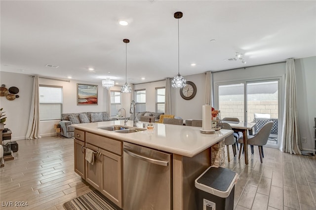 kitchen featuring dishwasher, sink, an island with sink, and plenty of natural light