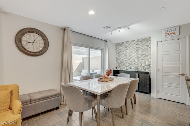 dining area featuring light wood-type flooring and track lighting