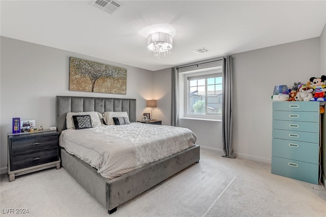 bedroom with light colored carpet and a chandelier