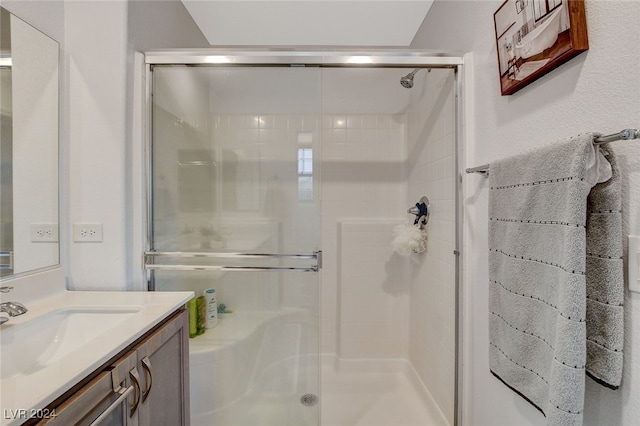 bathroom featuring vaulted ceiling, a shower with shower door, and vanity