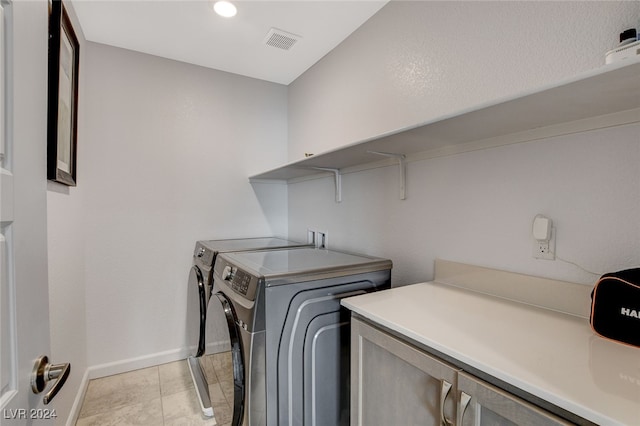 washroom featuring light tile patterned flooring and washer and dryer