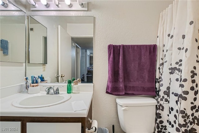 full bath with a textured wall, vanity, toilet, and a shower with curtain
