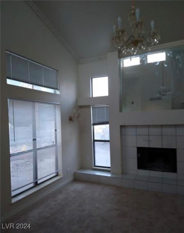 unfurnished living room with carpet floors, ornamental molding, high vaulted ceiling, and a tile fireplace