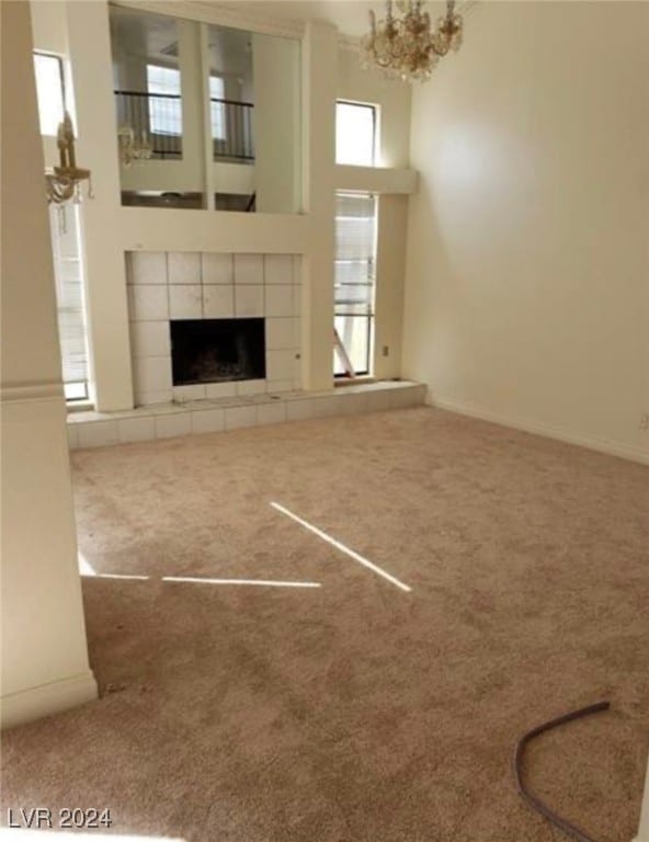 unfurnished living room featuring carpet floors, plenty of natural light, and a fireplace