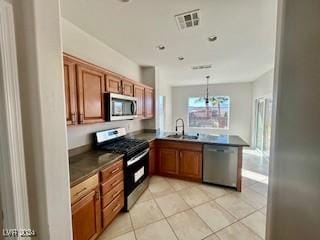 kitchen featuring kitchen peninsula, appliances with stainless steel finishes, sink, light tile patterned floors, and hanging light fixtures