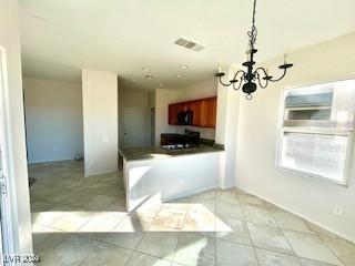 kitchen with kitchen peninsula, light tile patterned flooring, decorative light fixtures, and a notable chandelier