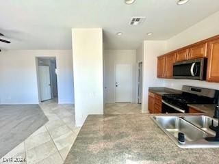 kitchen featuring black range oven, ceiling fan, light tile patterned flooring, and sink