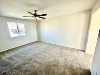 carpeted spare room with ceiling fan