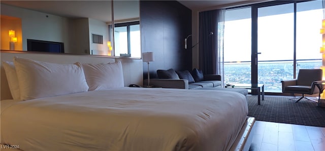 bedroom with expansive windows and light hardwood / wood-style floors