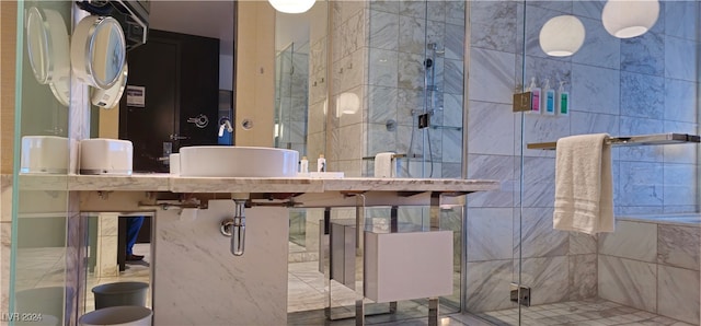 bathroom featuring tile walls and a shower with shower door