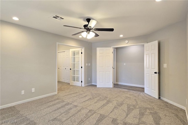 carpeted spare room with ceiling fan