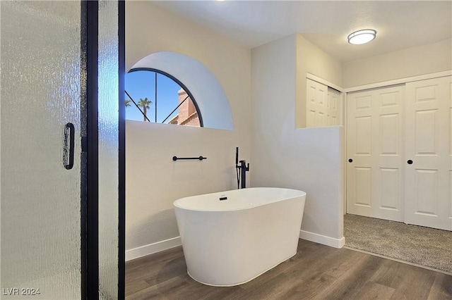 bathroom with wood-type flooring and a washtub