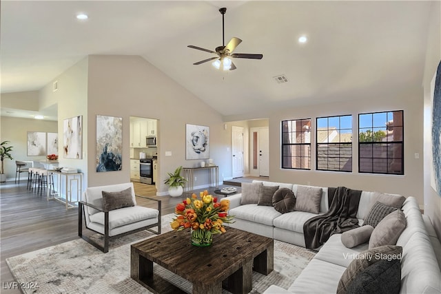 living room with high vaulted ceiling, ceiling fan, and light wood-type flooring