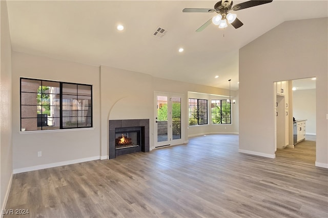 unfurnished living room featuring ceiling fan, a fireplace, high vaulted ceiling, and light hardwood / wood-style flooring