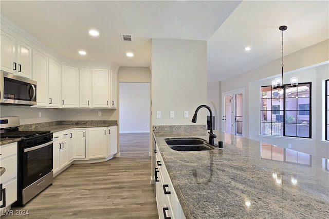 kitchen featuring sink, decorative light fixtures, white cabinets, and appliances with stainless steel finishes