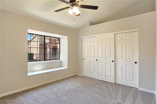 unfurnished bedroom featuring ceiling fan, a closet, lofted ceiling, and carpet