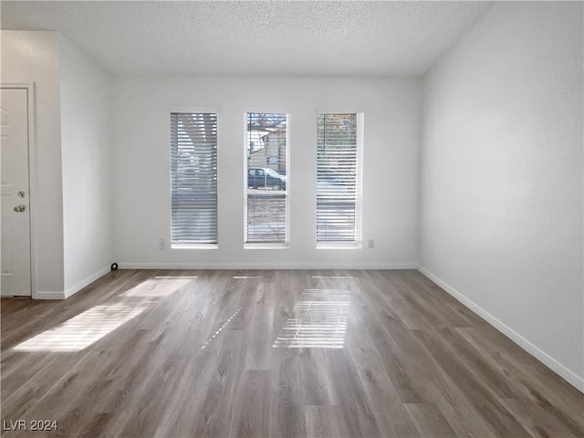 empty room featuring hardwood / wood-style flooring and a textured ceiling