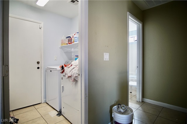 laundry room with light tile patterned flooring and washing machine and dryer