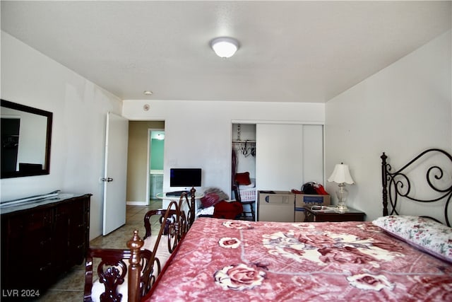 bedroom with tile patterned flooring and a closet