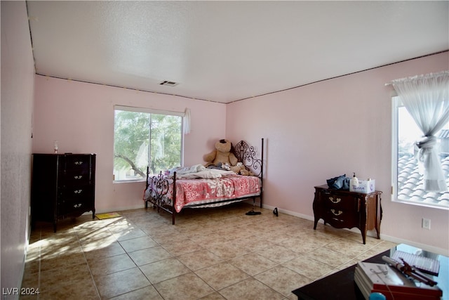 tiled bedroom with multiple windows