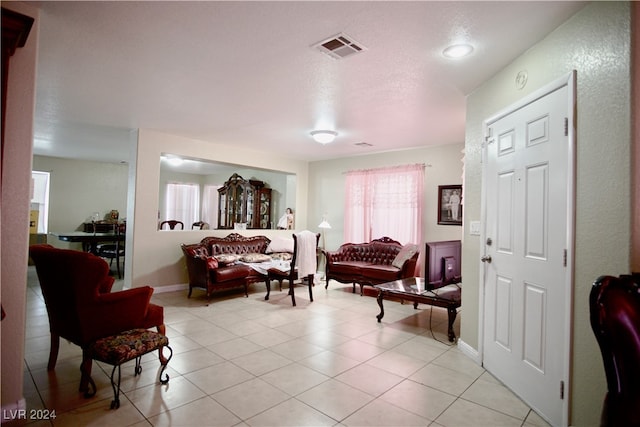 living area with light tile patterned flooring and a textured ceiling