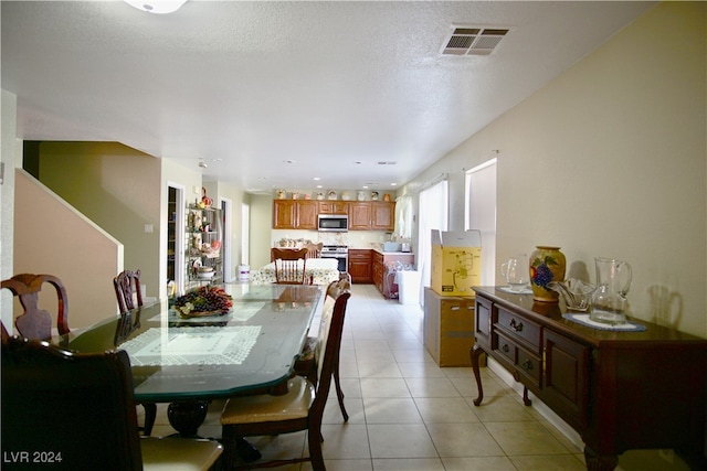 tiled dining area featuring a textured ceiling