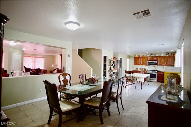 tiled dining area featuring a textured ceiling