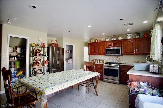 kitchen with sink, appliances with stainless steel finishes, and light tile patterned floors