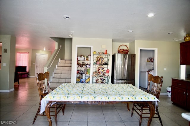 tiled dining room featuring washer / dryer