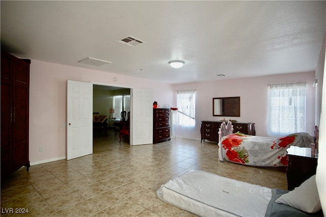 tiled bedroom featuring multiple windows