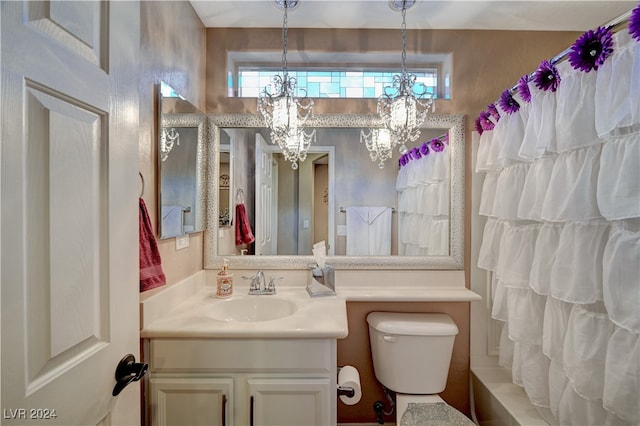 bathroom featuring toilet, a chandelier, and vanity