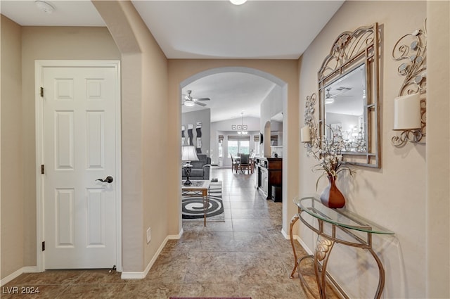 corridor featuring vaulted ceiling and a notable chandelier