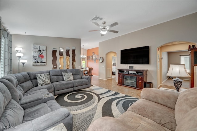 living room with ceiling fan with notable chandelier and light tile patterned floors